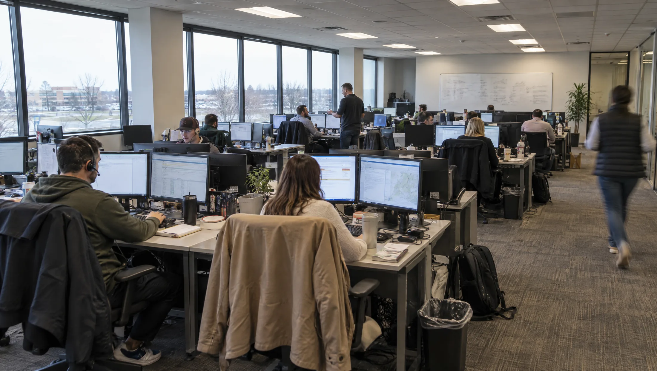 A freight brokerage floor in daylight, people working at their desks